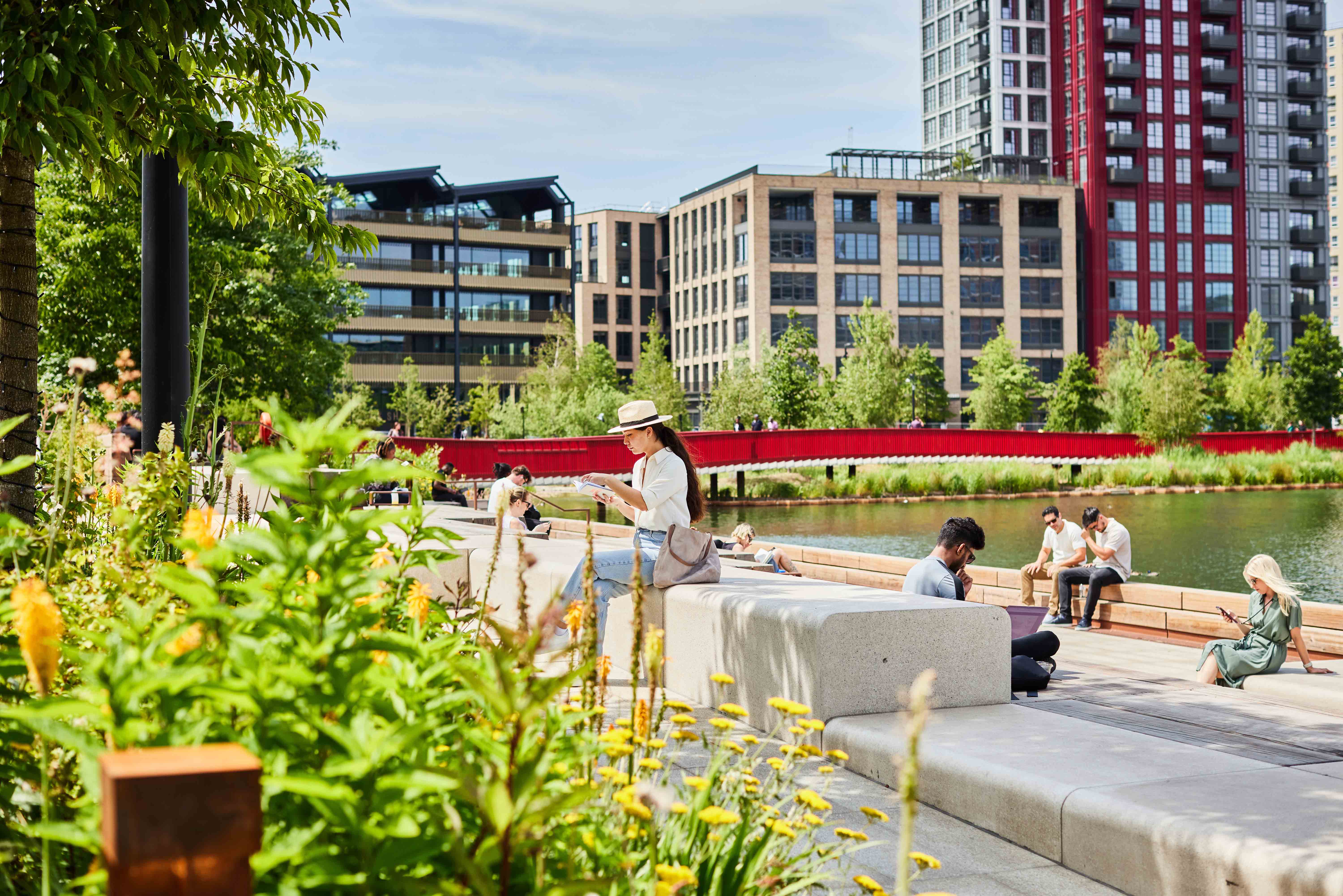 People reading and relaxing beside Canada Dock, with Three Deal Porters in the background